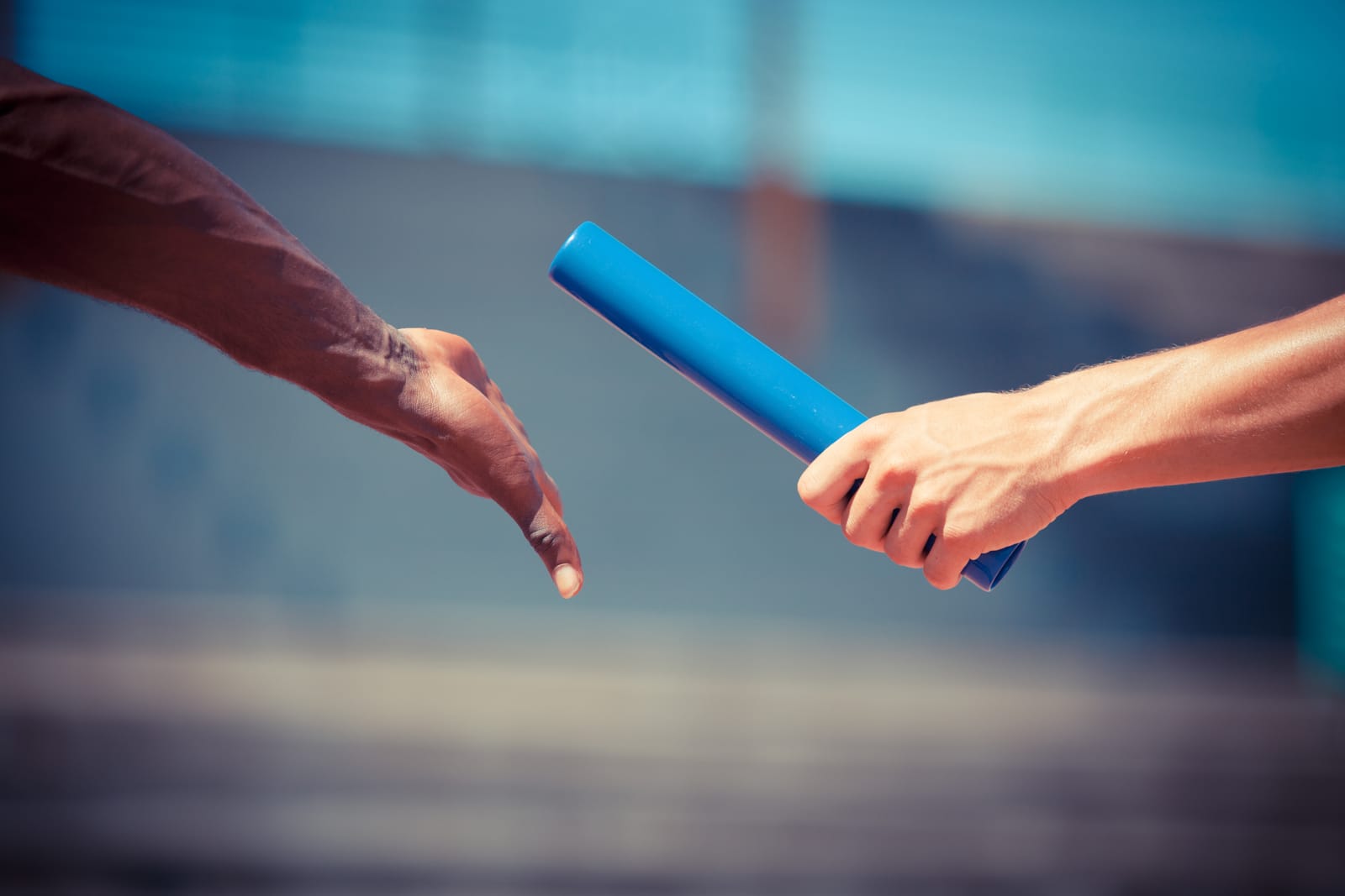 A relay race handoff representing coordinated process